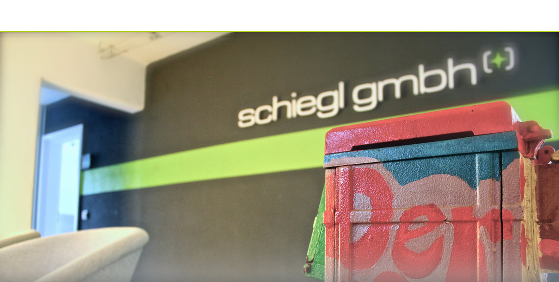 Büroraum der schiegl GmbH mit Logo im Hintergrund